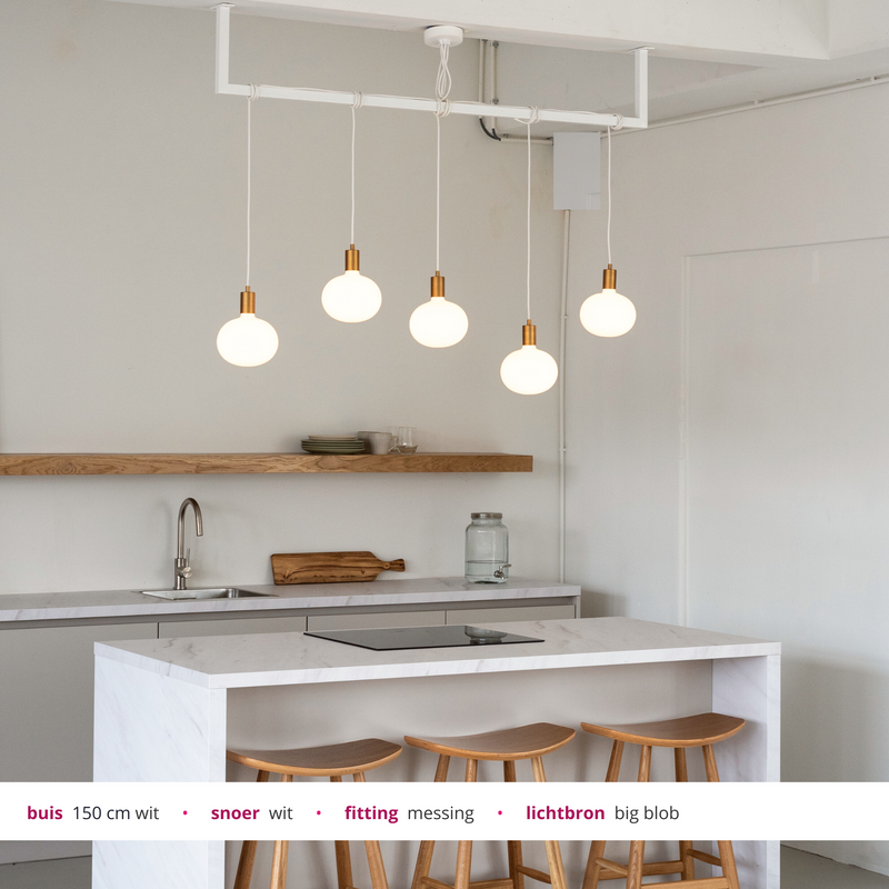 Loftbar wit buislamp met messing en grote witte lamp bollen boven keukeneiland
