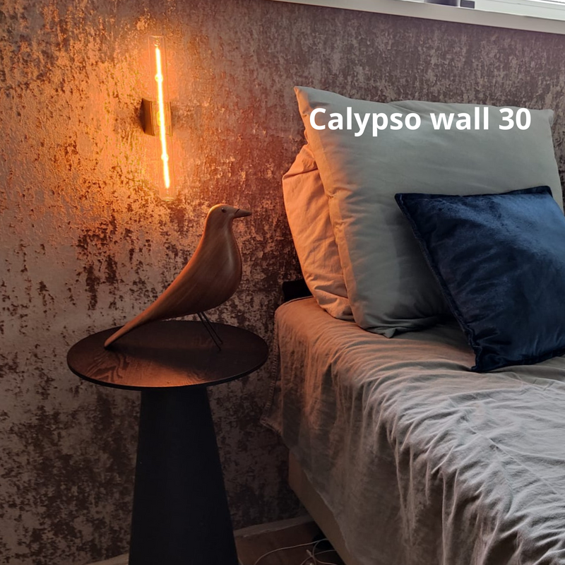 Moderne wandlamp naast bed nachtkastje